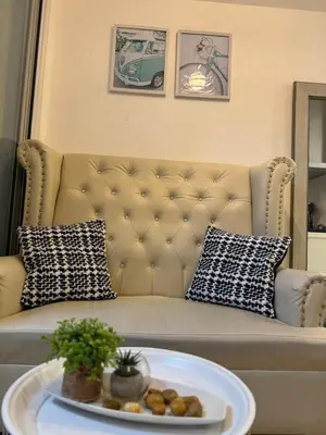 a couch with pillows and a plate on a table at A&J azure getaway in Manila