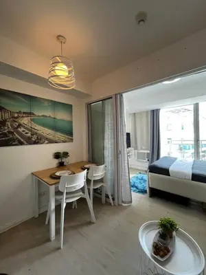 a bedroom with a bed and a table and a dining room at A&J azure getaway in Manila