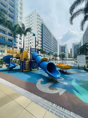 a playground with a blue slide in a city at Sea Residences 2 BR by TVANS in Manila