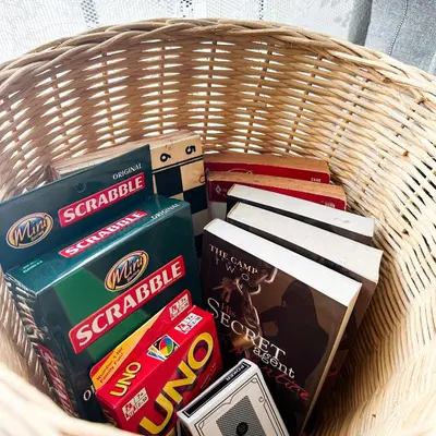 a wicker basket with books and other items in it at Crizzy's Hub Crizel at Shore Residences - 1BR with Balcony and Amenity view - Netflix and Disney - Near MOA in Manila