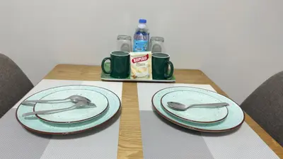 a wooden table with two plates and spoons on it at Monarch Parksuites Balmoral Place Unit 1616 in Manila