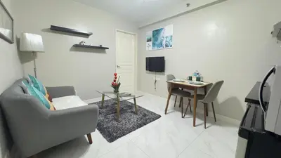a living room with a chair and a table at Monarch Parksuites Balmoral Place Unit 1616 in Manila