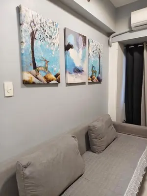 a living room with four paintings on the wall at Experience Unforgettable Moments in Manila