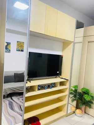 a living room with a tv and a mirror at Sea Residence By Kenshin Staycation in Manila