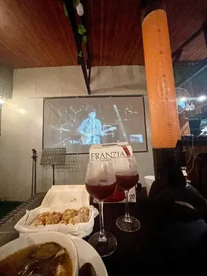 a table with a glass of wine and a tv at Binangonan Primes Tiny Home with FREE breakfast and Plunge Pool in Binangonan