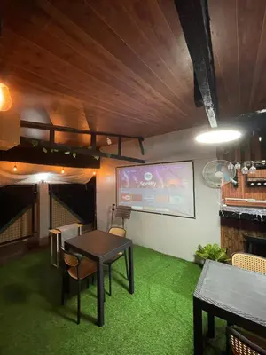 a room with a table and chairs and a screen at Binangonan Primes Tiny Home with FREE breakfast and Plunge Pool in Binangonan