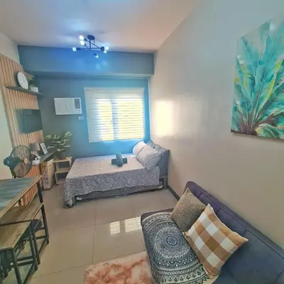 a living room with a bed and a couch at HOMELY Green 2 Residences near DLSUHSI in Dasmariñas