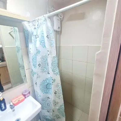 a bathroom with a shower curtain and a sink at HOMELY Green 2 Residences near DLSUHSI in Dasmariñas