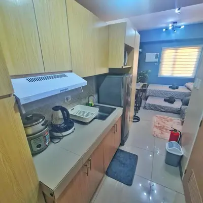 a small kitchen with a sink and a refrigerator at HOMELY Green 2 Residences near DLSUHSI in Dasmariñas