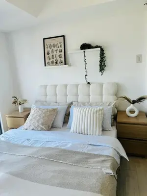 a bedroom with a large white bed with pillows at Cornelia Street at Azure Urban Resort Residences in Manila