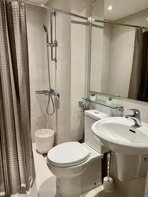 a white bathroom with a toilet and a sink at Cornelia Street at Azure Urban Resort Residences in Manila