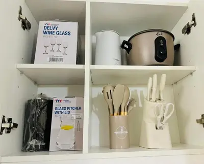 a kitchen shelf with wine glasses and utensils at Cornelia Street at Azure Urban Resort Residences in Manila