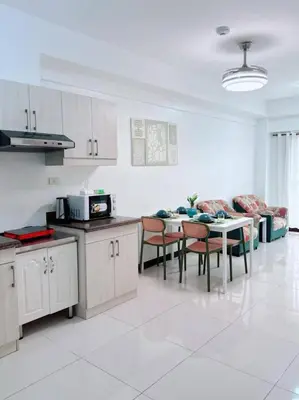 a kitchen and dining room with a table and chairs at Tan condo fairway in Manila