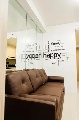 a brown couch in a room with a happy wall at Premium family Suite near MOA in Manila