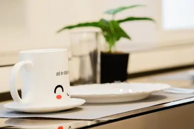 a white coffee cup sitting on a table with a plate at Premium family Suite near MOA in Manila