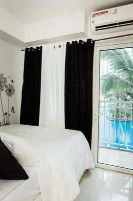 a bedroom with a white bed and a window at Premium family Suite near MOA in Manila