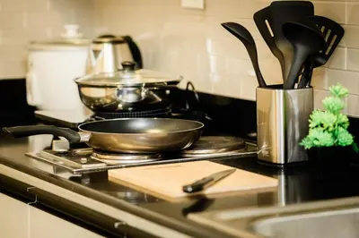 a kitchen counter with a frying pan on a stove at Premium family Suite near MOA in Manila