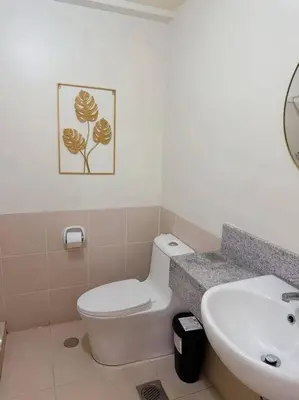 a bathroom with a white toilet and a sink at Tan condo city view 01 in Manila