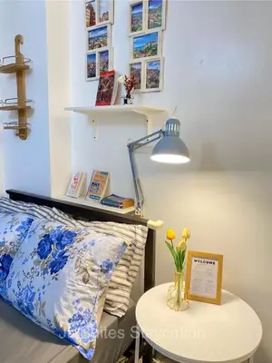 a bedroom with a bed and a table with a lamp at JL Suite Staycation near Venice Grand Canal Mall in Manila