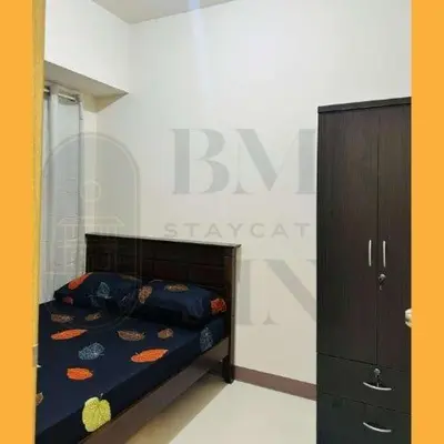 a small bedroom with a bed and a dresser at Staycation Manila at Coast Residences in Manila