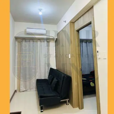 a black chair in a room with a window at Staycation Manila at Coast Residences in Manila