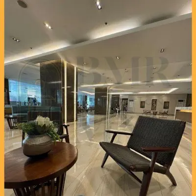 a lobby with a vase on a table and a chair at Staycation Manila at Coast Residences in Manila