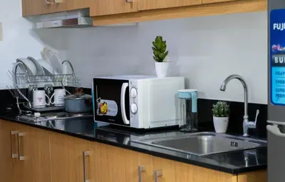 a microwave sitting on a counter in a kitchen at Unistay SHELL Residence Amazing pool near MOA in Manila