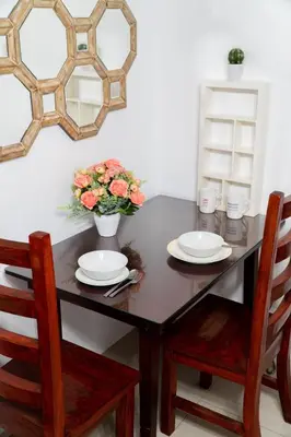 a table with two plates and a vase with flowers at Unistay SHELL Residence Amazing pool near MOA in Manila