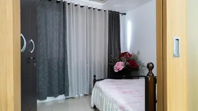 a bedroom with a bed and a vase of flowers at Unistay SHELL Residence Amazing pool near MOA in Manila