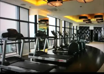 a gym with a row of treadmills in a room at Gramercy Residences Cozy 1BR Suite with 600mbps & Free amenities City view in Manila