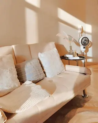 a couch with pillows on it in a living room at Gramercy Residences Cozy 1BR Suite with 600mbps & Free amenities City view in Manila