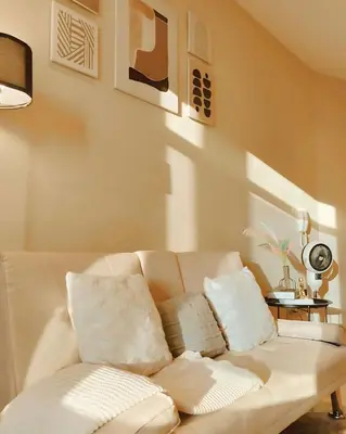 a living room with a white couch with pillows at Gramercy Residences Cozy 1BR Suite with 600mbps & Free amenities City view in Manila