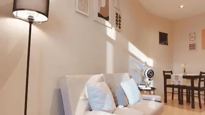 a living room with a white couch and a lamp at Gramercy Residences Cozy 1BR Suite with 600mbps & Free amenities City view in Manila