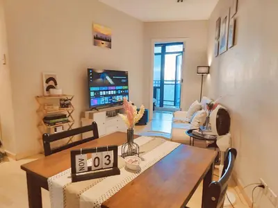 a living room with a table and a tv at Gramercy Residences Cozy 1BR Suite with 600mbps & Free amenities City view in Manila