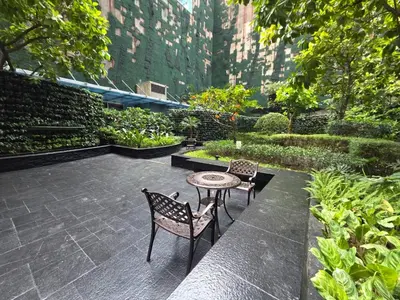 a patio with two chairs and a table in a garden at Gramercy Residences Cozy 1BR Suite with 600mbps & Free amenities City view in Manila