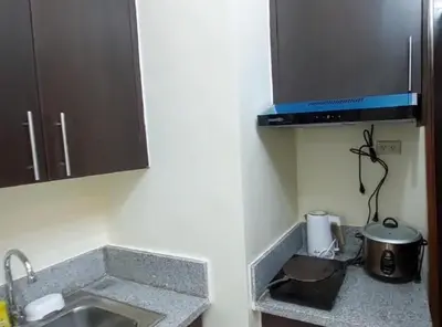 a kitchen counter with a sink and a microwave at 21K Pioneer Woodlands Mandaluyong in Manila