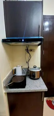 a kitchen counter with a pot and a pan on it at 21K Pioneer Woodlands Mandaluyong in Manila