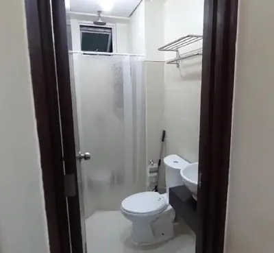 a white bathroom with a toilet and a sink at 21K Pioneer Woodlands Mandaluyong in Manila