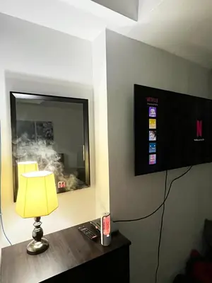 a room with a tv and a lamp on a table at Azure Staycation by Casa Lepap in Manila