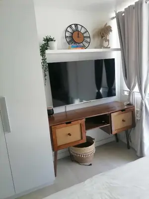 a living room with a tv and a desk at Luxury 1Bedroom Condo Unit Near Manila Airport - Azure Resort Residences in Manila