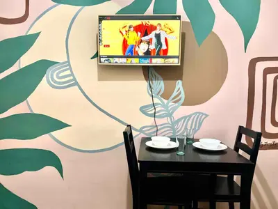 a dining room with a table and a tv on a wall at Studio in the Metro I Near MRT I WiFi in Manila