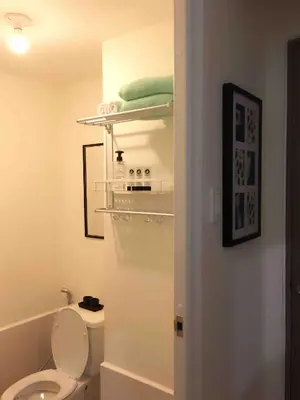 a bathroom with a toilet and a shelf on the wall at Studio in the Metro I Near MRT I WiFi in Manila