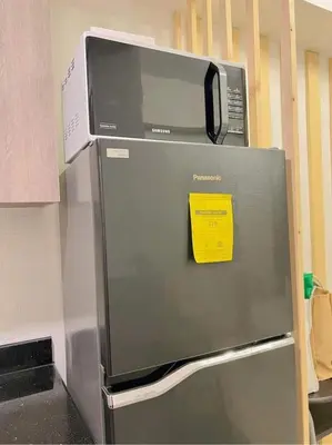 a microwave on top of a refrigerator in a kitchen at Cozy 1 BR in EDSA Mandaluyong in Manila