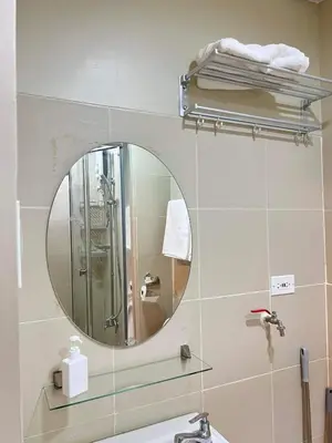 a bathroom with a mirror and a sink at Cozy 1 BR in EDSA Mandaluyong in Manila
