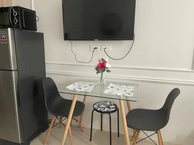 a table with two chairs and a tv on a wall at shore residences 1 -City Spark staycation in Manila