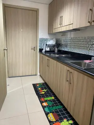 a kitchen with wooden cabinets and a tile floor at shore residences 1 -City Spark staycation in Manila