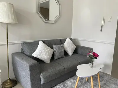 a living room with a gray couch and a mirror at shore residences 1 -City Spark staycation in Manila