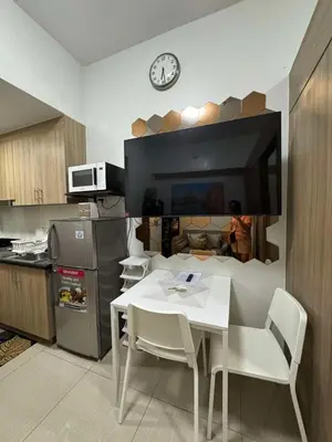 a kitchen with a white table and chairs and a clock at Shore 2 Residences Tower 1 in Manila