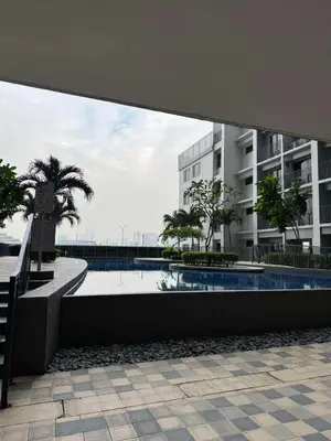 a swimming pool with palm trees and a building at Shore 2 Residences Tower 1 in Manila