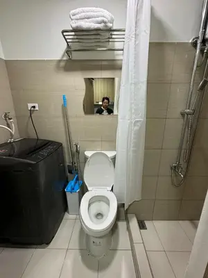 a man taking a picture of a bathroom with a toilet at Shore 2 Residences Tower 1 in Manila